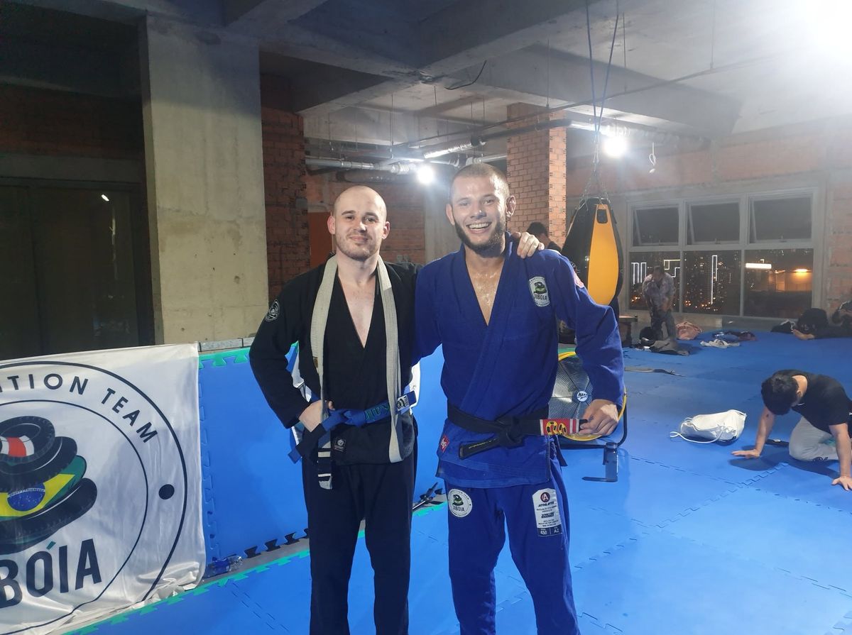 Kain in his gi after jiu-jitsu training, next to a black belt